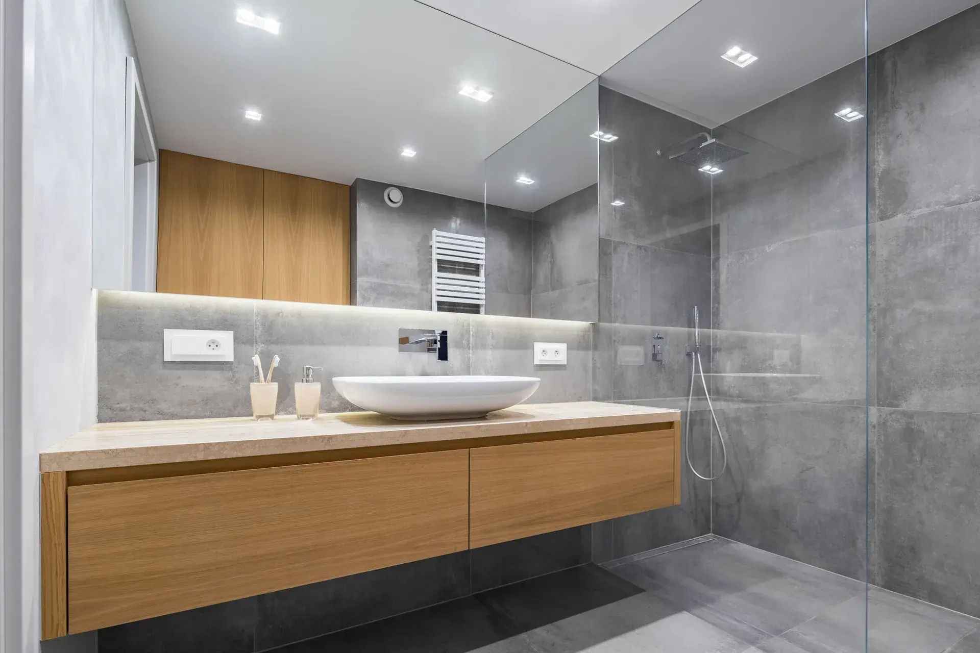 Grey tile bathroom with floating oak vanity